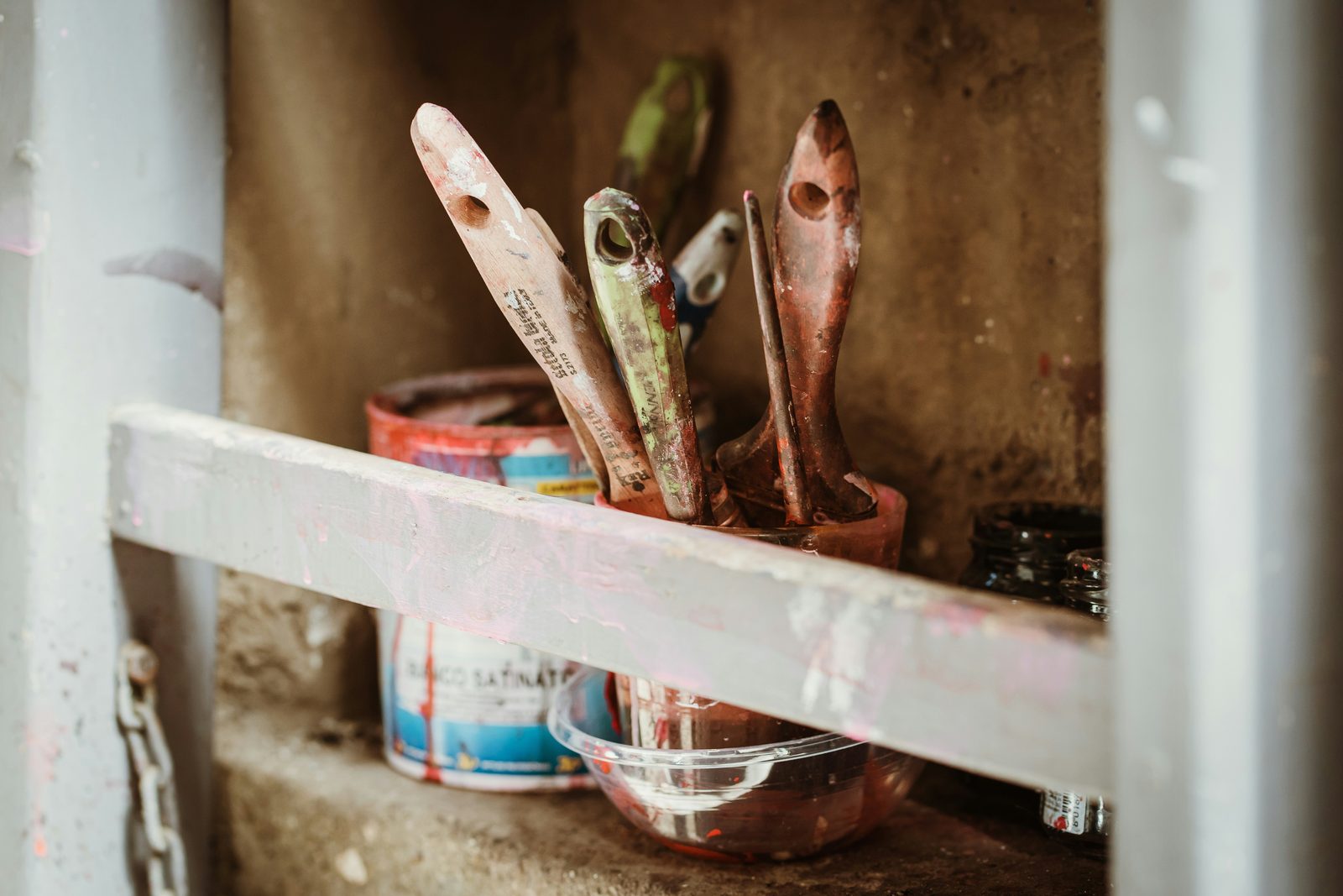 Brushes and paint tins on a shelf
