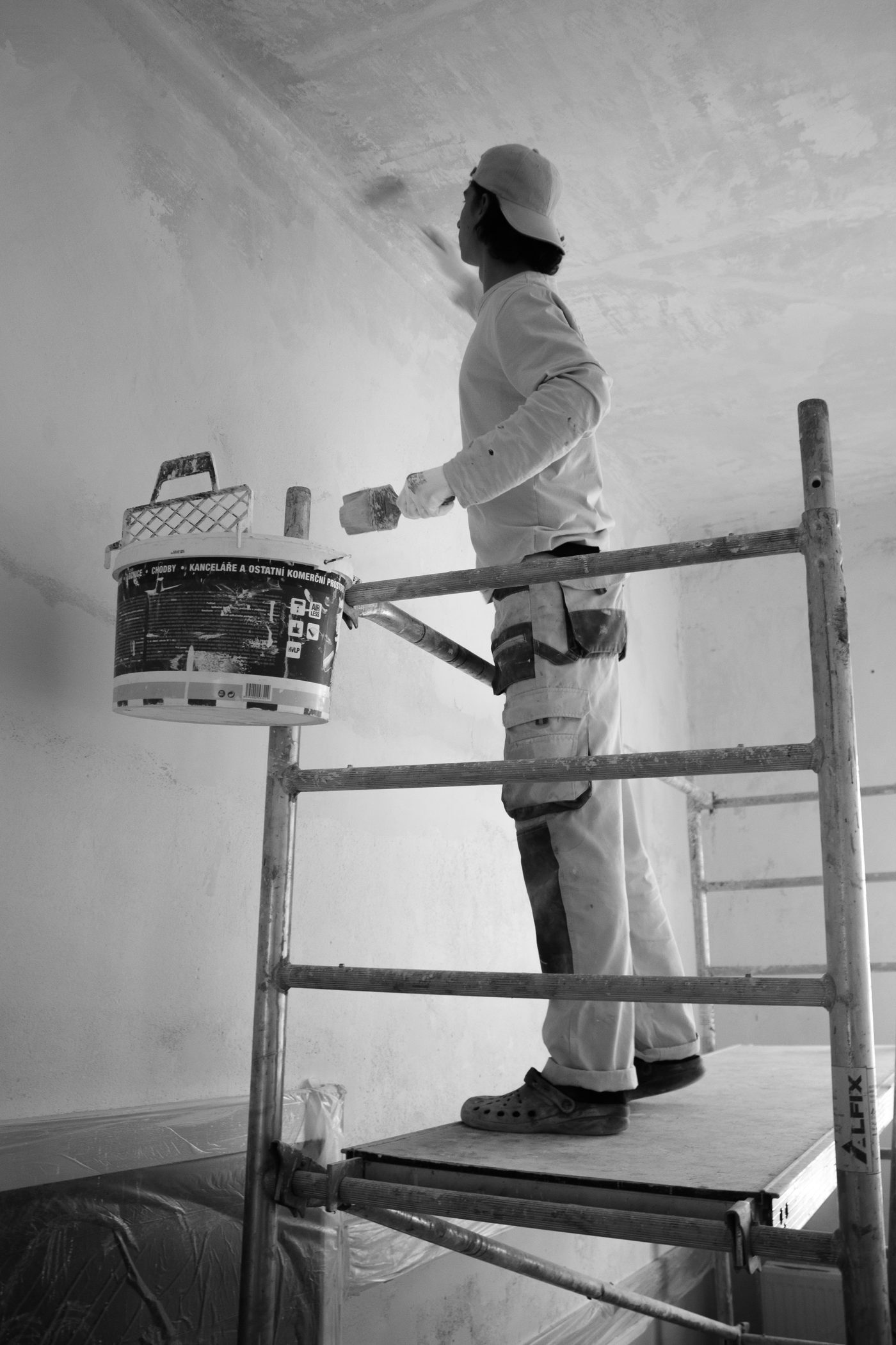 Painter cutting in a ceiling from a scaffold
